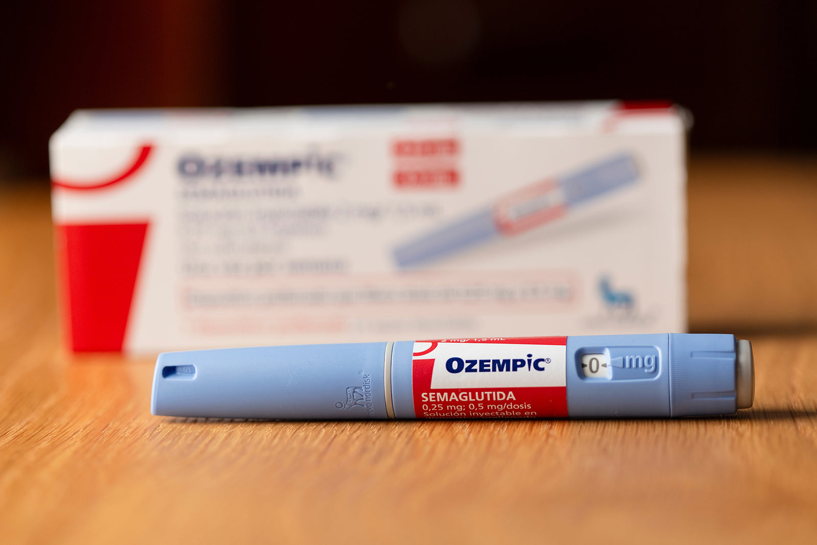 An Ozempic syringe sitting in front of an Ozempic box